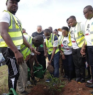 Dr-Siaw-Adjepong-with-former-President-Rawlings-behind-planting-a-tree.-397x405